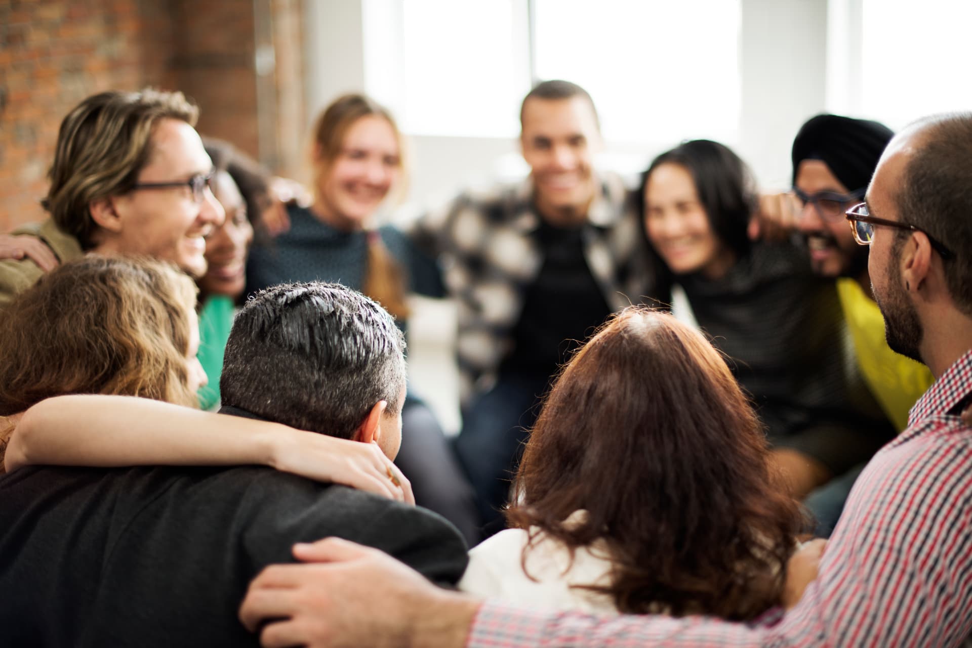 Personas de la comunidad NOOW abrazadas y sonriendo