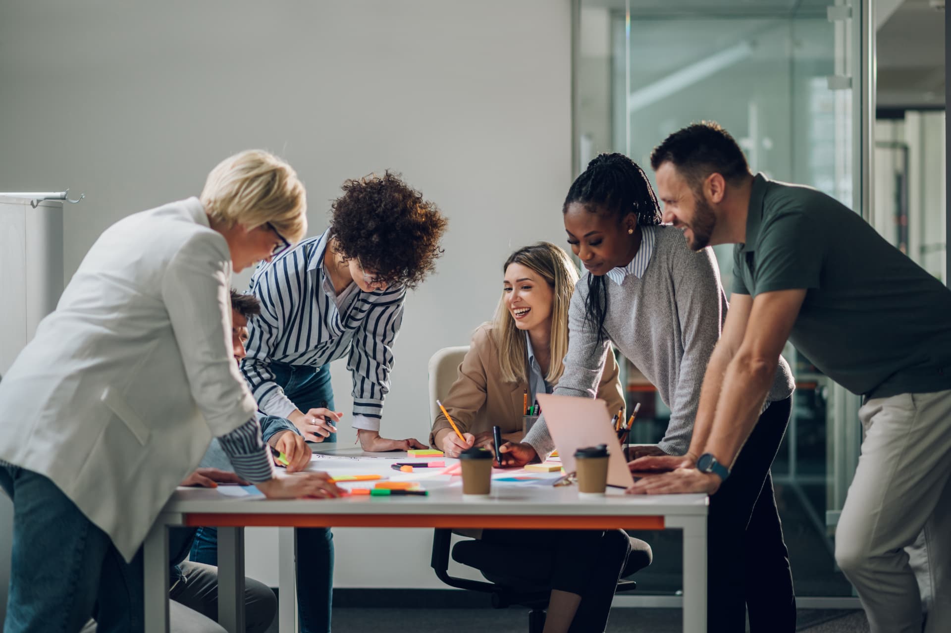 Equipo colaborando alrededor de una mesa de trabajo